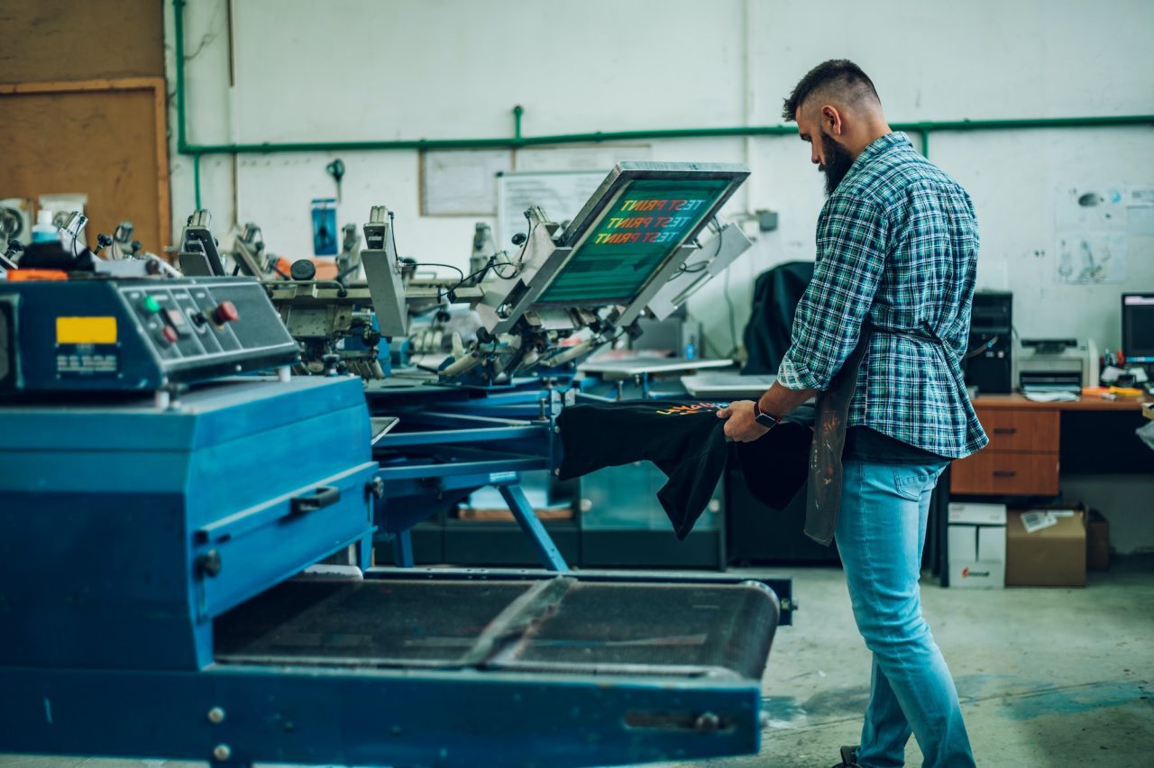 male-worker-using-the-printing-machine-in-a-workshop.jpg